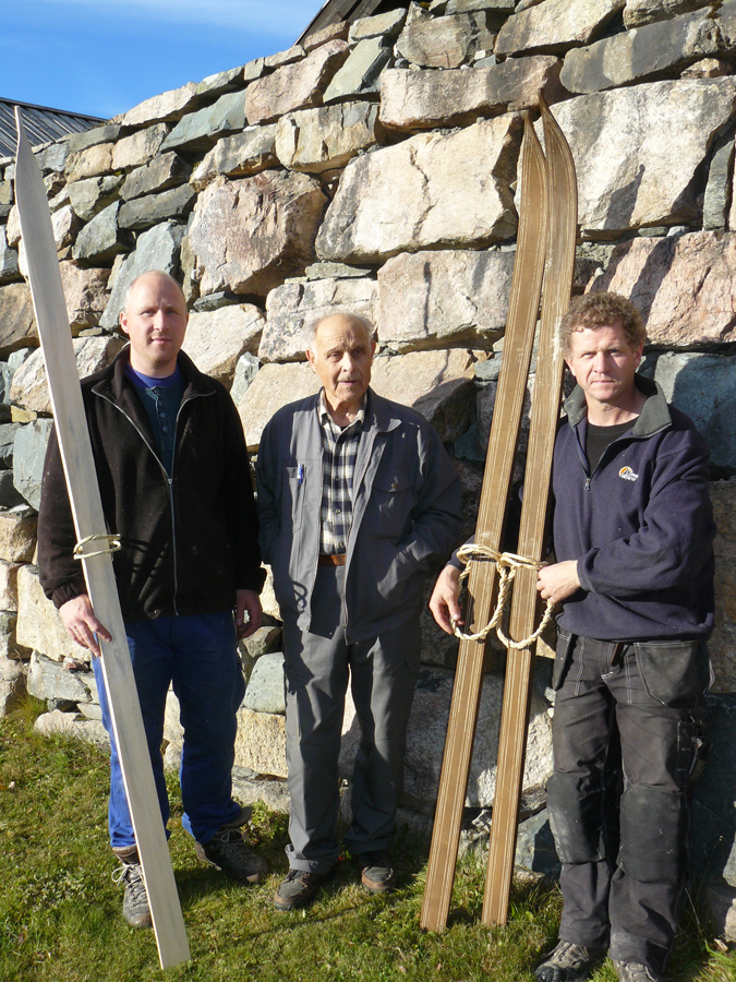Terje Haugen, Åsmund Kleiv and Tarjei Gjelstad posing with a pair of traditional skis
